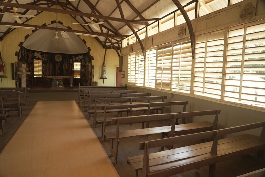 Inside a wooden church featuring louvres and a tall ceiling