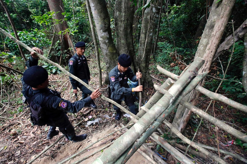 Border patrol police officers dismantle an abandoned migrant camp.