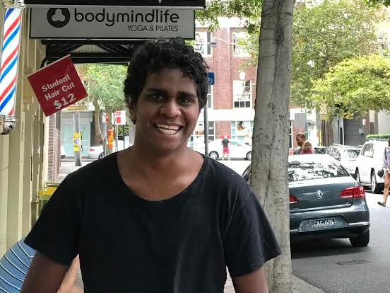 A young man stands in a street in Sydney.