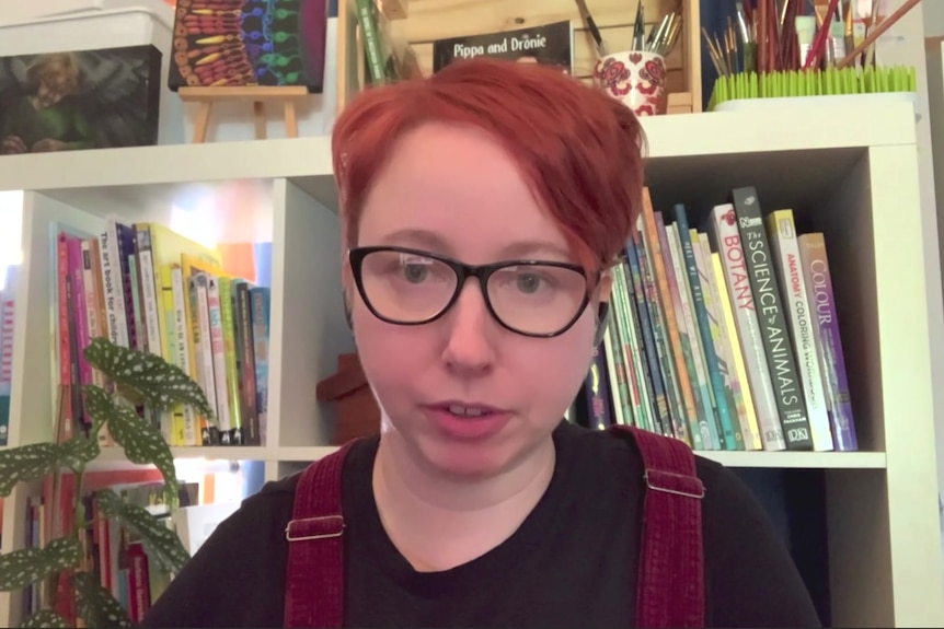 Sarah Davies sits in front of a bookcase.