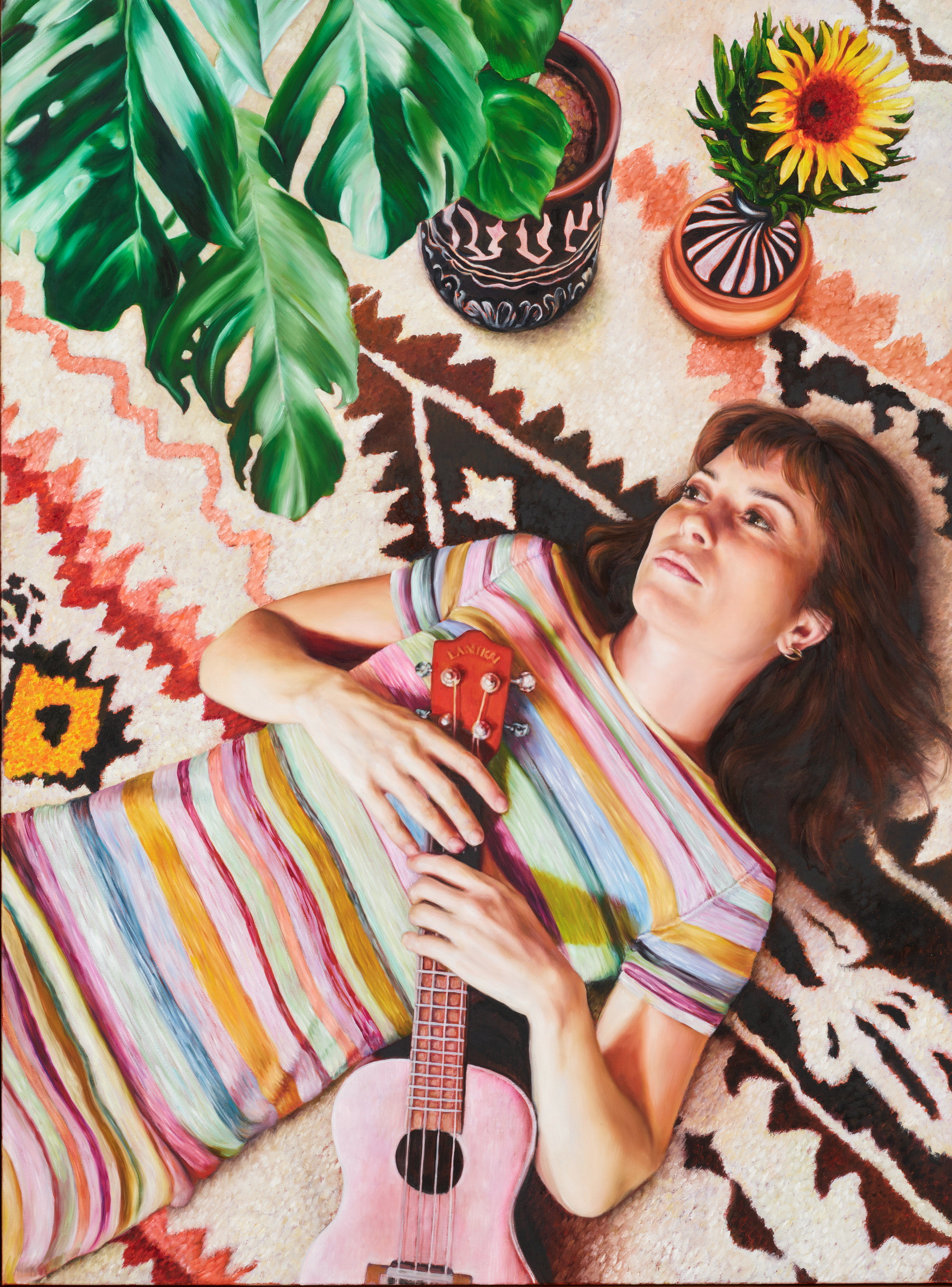 A portrait of Missy Higgins, a white brunette woman in a striped dress, lying down and holding a ukelele.