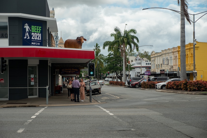 A statue of a bull on an awning in Rockhampton's CBD, with cars and people on the street below, November 2021.