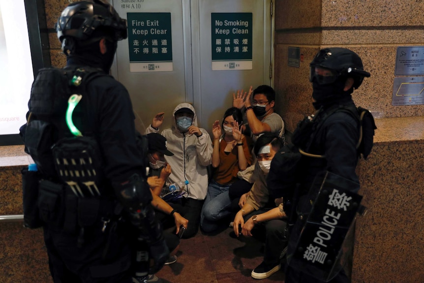 People are detained by riot police during a march against national security law in Hong Kong.