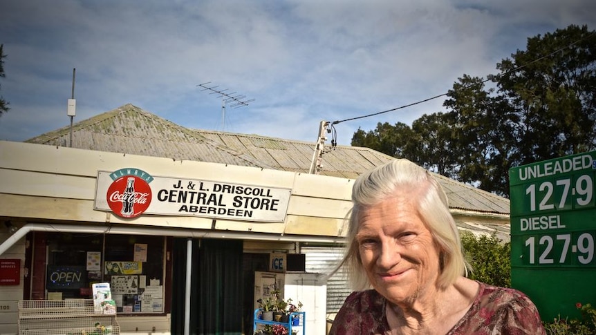 Lorna Driscoll is standing outside her family's general store building in Aberdeen in NSW.