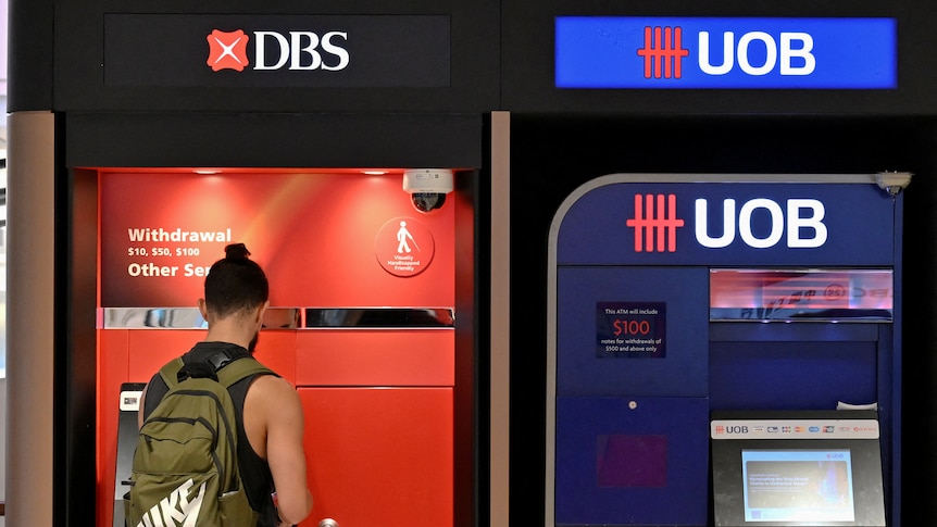 A man withdraws cash from an ATM in Singapore