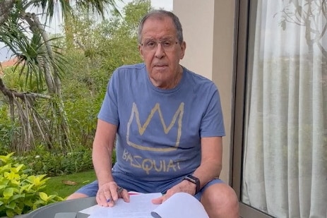 Russian Foreign Minister Sergei Lavrov reads documents on a patio in Bali.