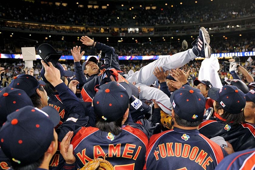 Team Japan throw their manager Tatsunori Hara into the air after they defeated Team Korea