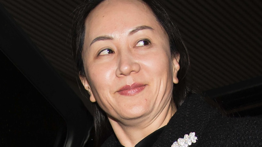 Meng Wanzhou arriving in court wearing a black jacket with a flower diamond brooch.
