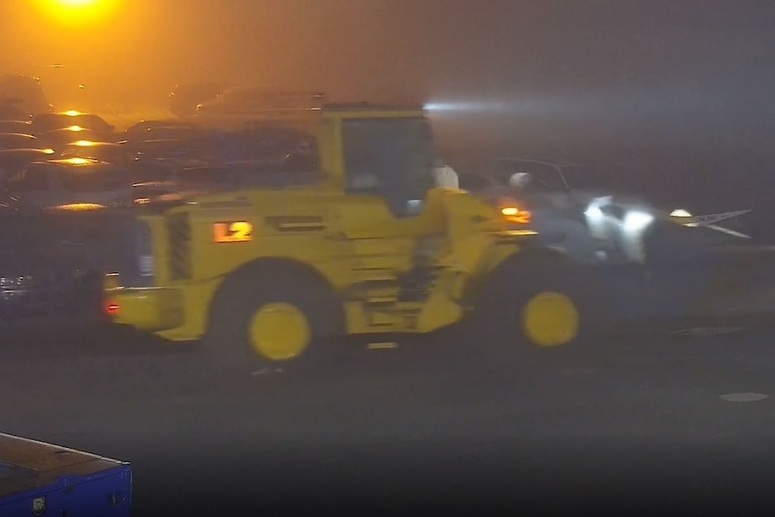 A grainy CCTV shot of a yellow front loader
