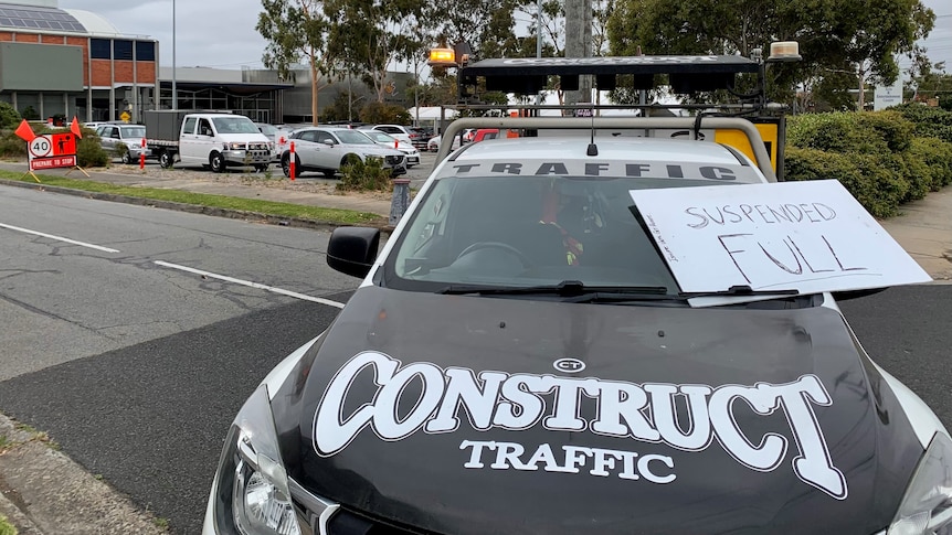 A ute with Construct Traffic sign has a Suspended Full placard placed on it. 