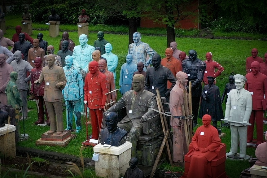 A collection of Chiang Kai-shek statues lumped together in a park 