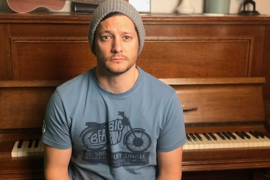 Rob Mills sitting in front of a piano