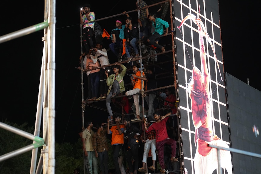Men climbing a scaffolding.