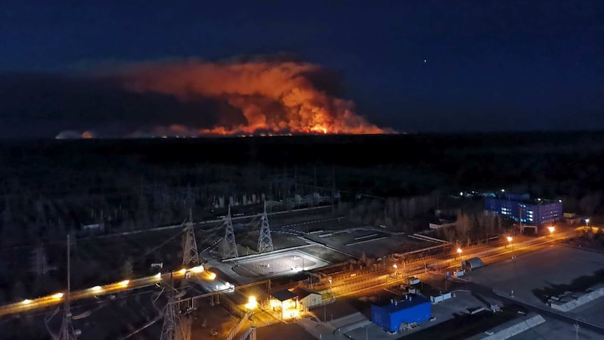 A forest fire is seen at night from the rooftop of Chernobyl's nuclear power plant