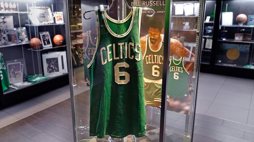 a Celtics jersey with the number 6 on front in a display case next to an image of Bill Russell