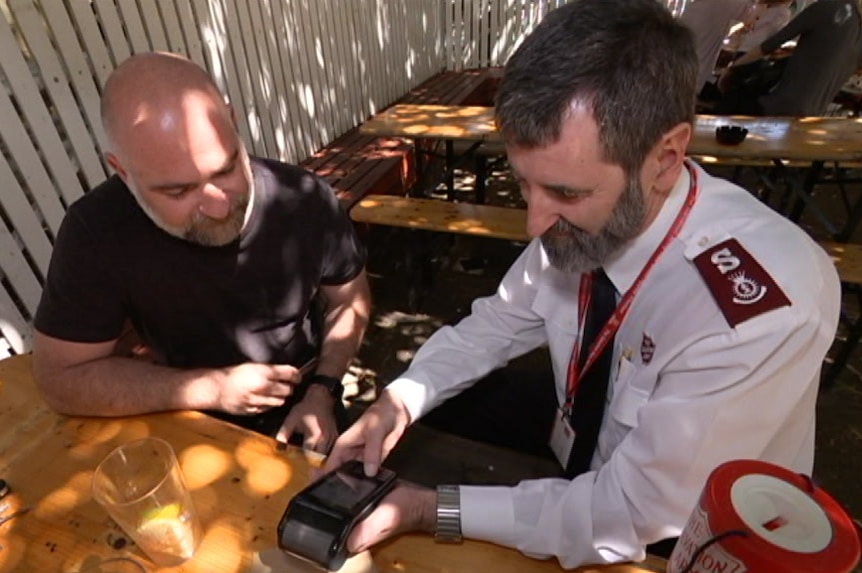 Major Hateley processes a donation at the pub