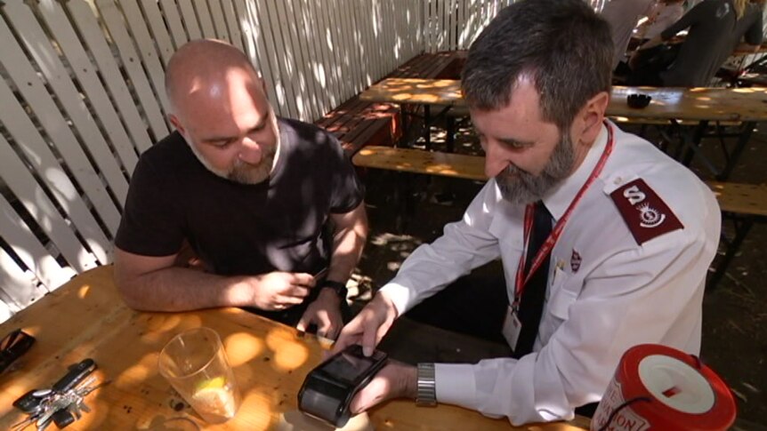 Major Hateley processes a donation at the pub