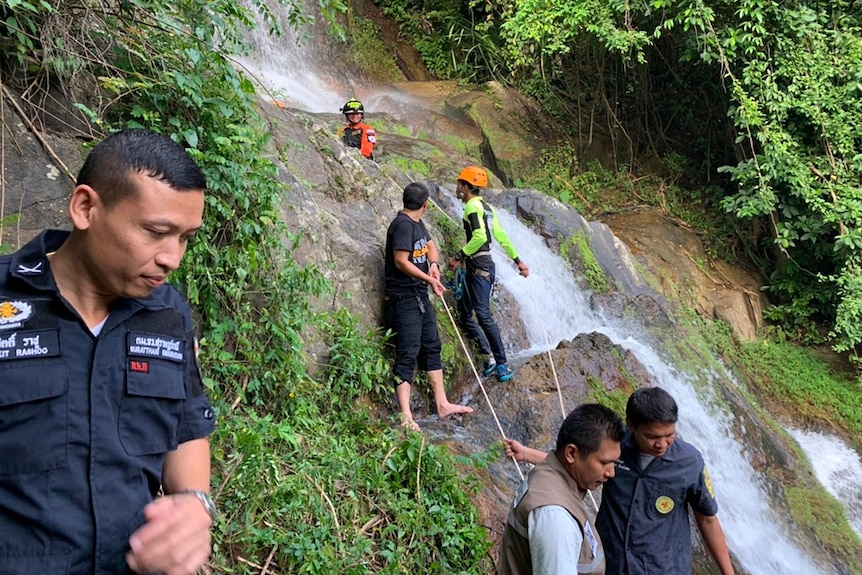 Rescuer going down a waterfall.