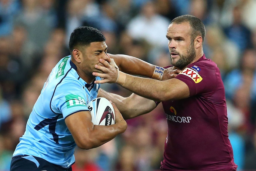 Tight encounter ... Daniel Tupou (L) tries to beat a Nate Myles tackle