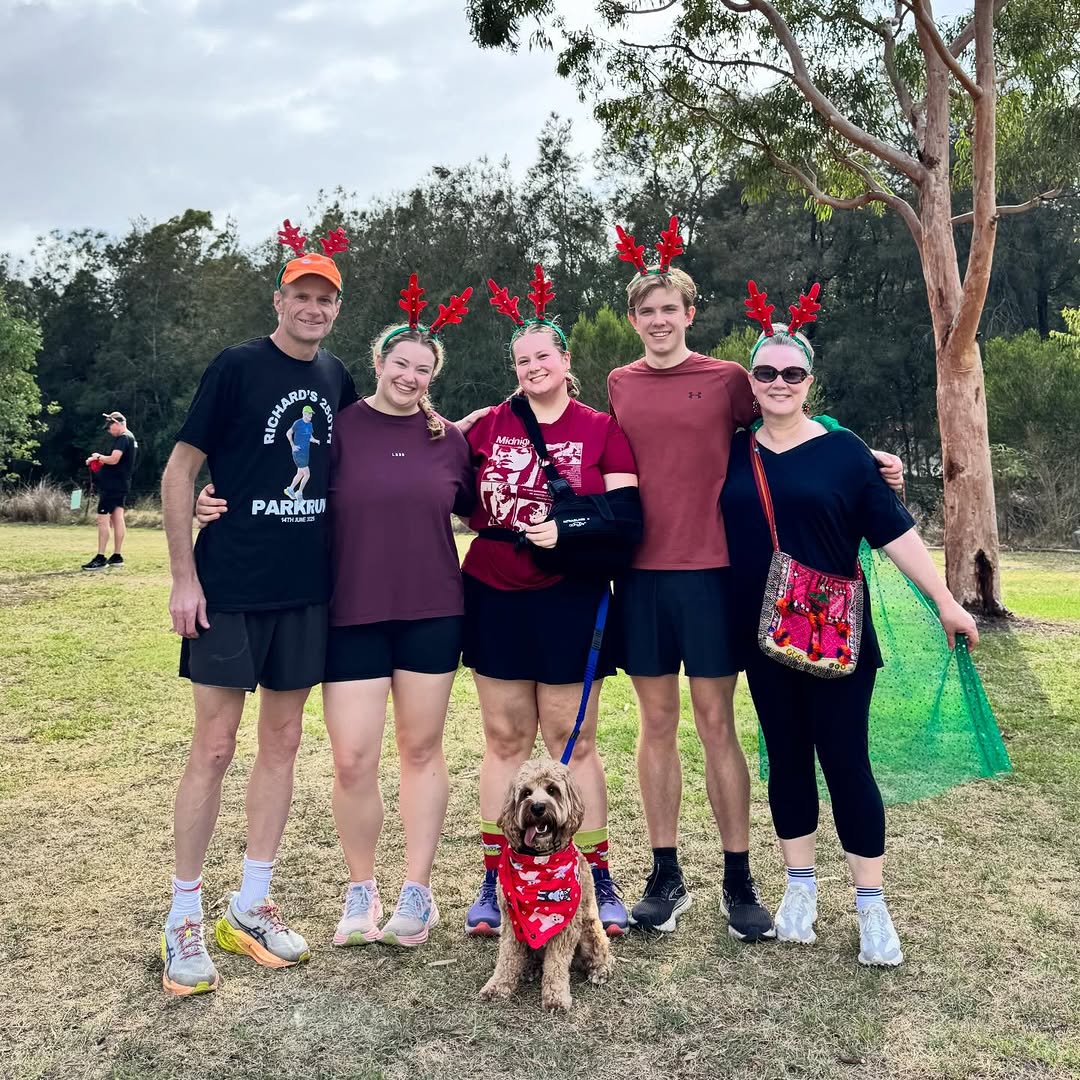 the colyer family wearing raindeer ears at a park with their dog