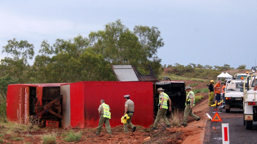 Northern Territory police inspect the scene of a Greyhound bus rollover on the Stuart Highway