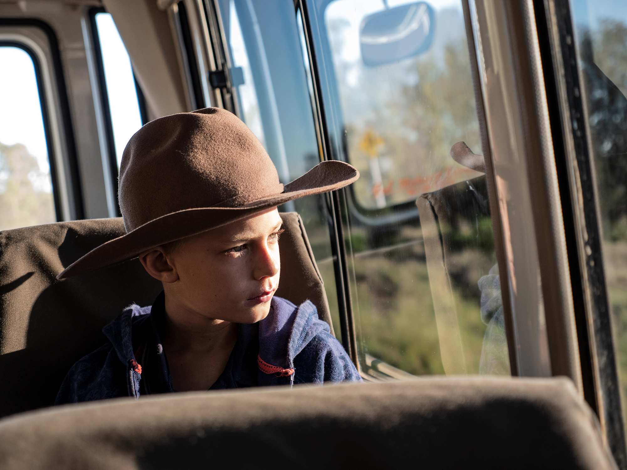 A young student looks out the window of a school bus