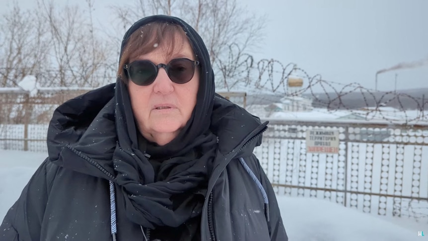 Lyudmila Navalnaya standing outside in the snow with a sad look on her face.