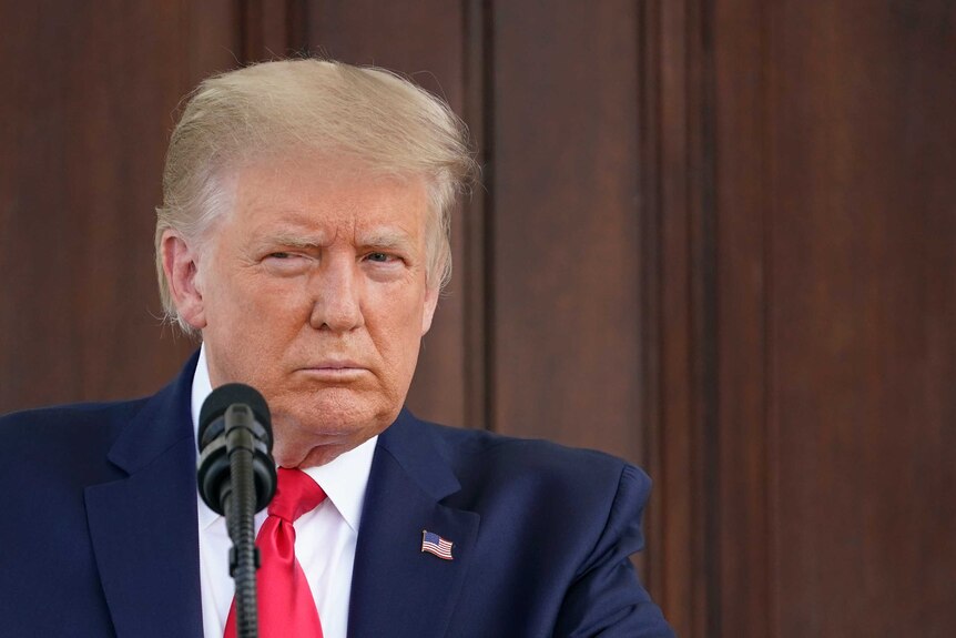 President Donald Trump listens to a reporter's question during a news conference