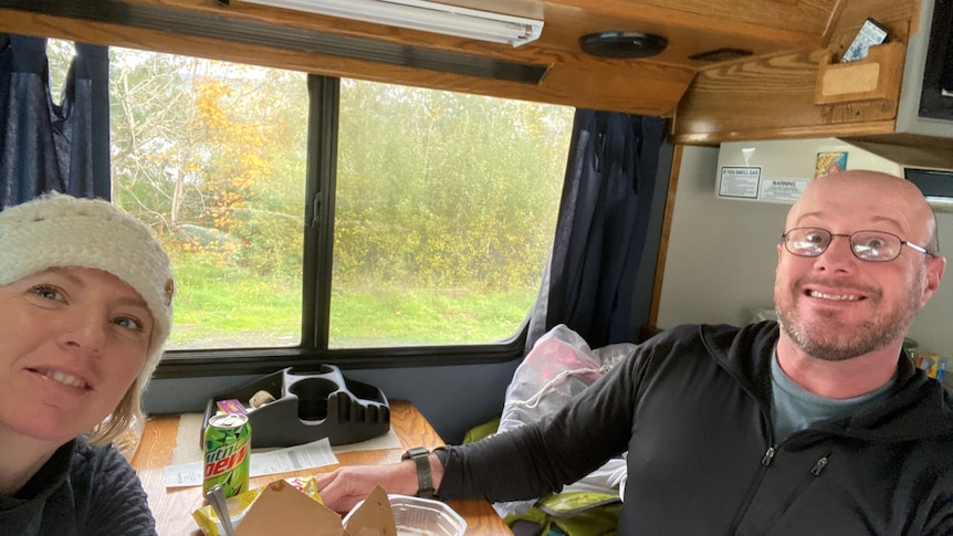 A man and a woman at a table in a caravan