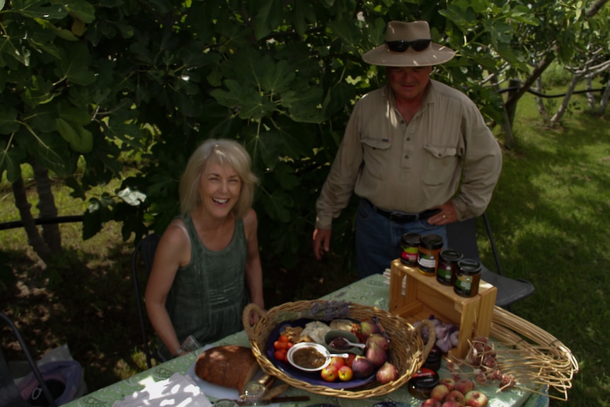 Dionne Mitchell and Ian Knox with a spread of their farm produce, at a table in their fig orchard.