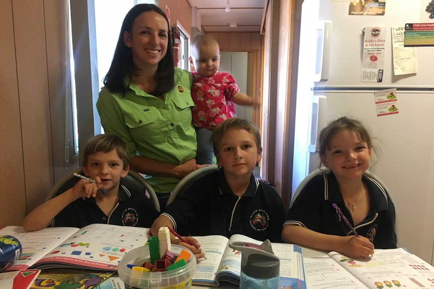 Leza Cook and her children at home with their schoolbooks.