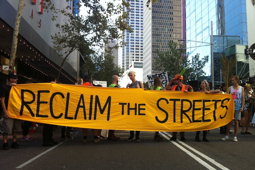 Protesters hold a sign that reads "Reclaim the Streets" outside Sydney's Star City Casino.