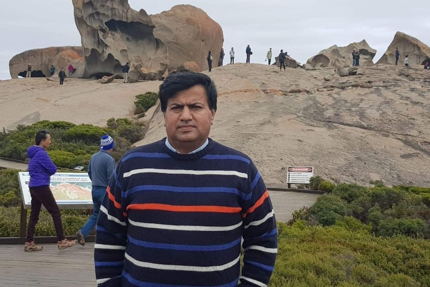 Muhammad Iqbal standing in front of rock formations