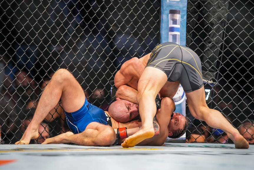 A man is caught in a submission hold during a UFC bout 