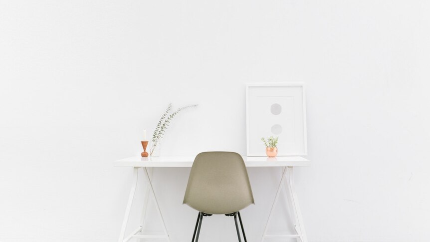 A white trestle work desk in an uncluttered home office space