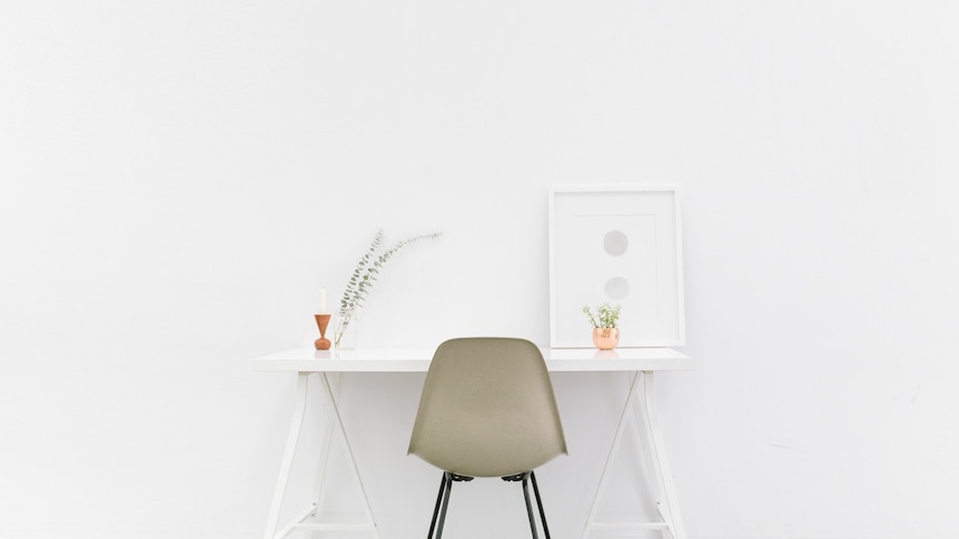 A white trestle work desk in an uncluttered home office space