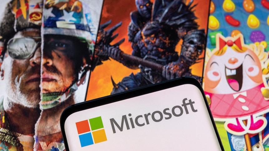 Microsoft logo in front of scenes from video games Call of Duty, World of Warcraft and Candy Crush