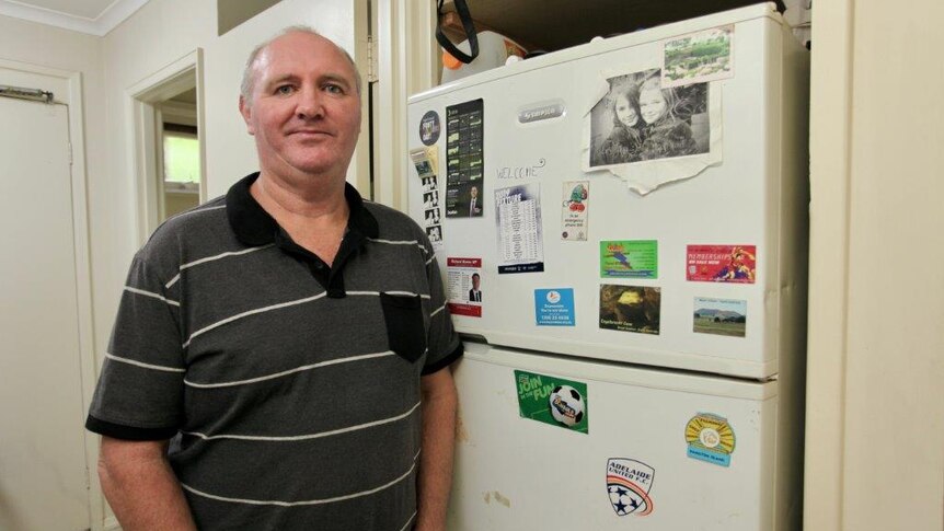 Ray Pilven stands next to his fridge.