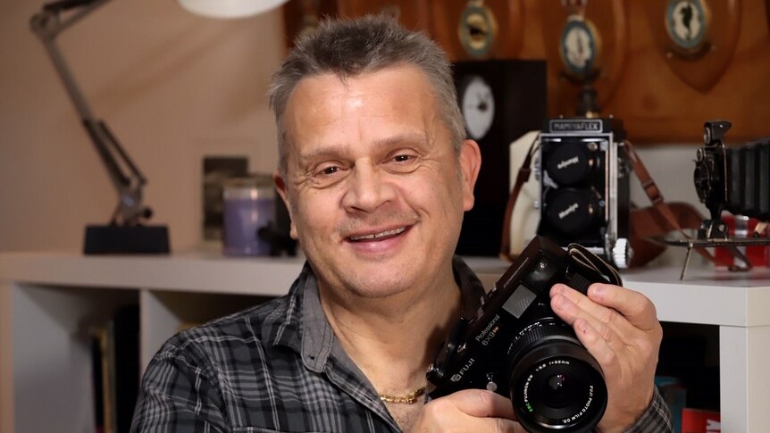 Roger Arnaud holds a camera