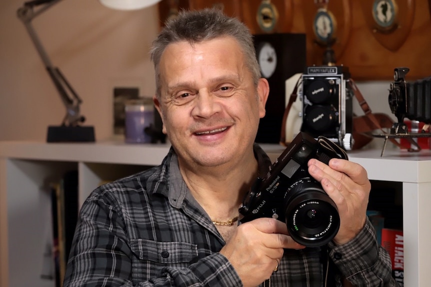 Roger Arnaud holds a camera