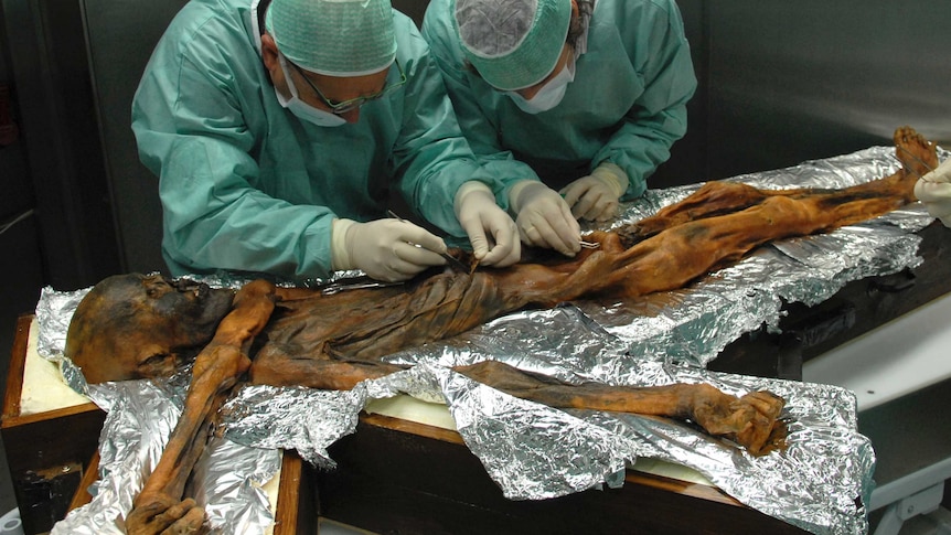 Researchers examine the body of a frozen hunter.