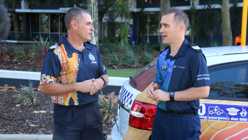 Two police officers wearing specially designed colourful shirts for NAIDOC week.