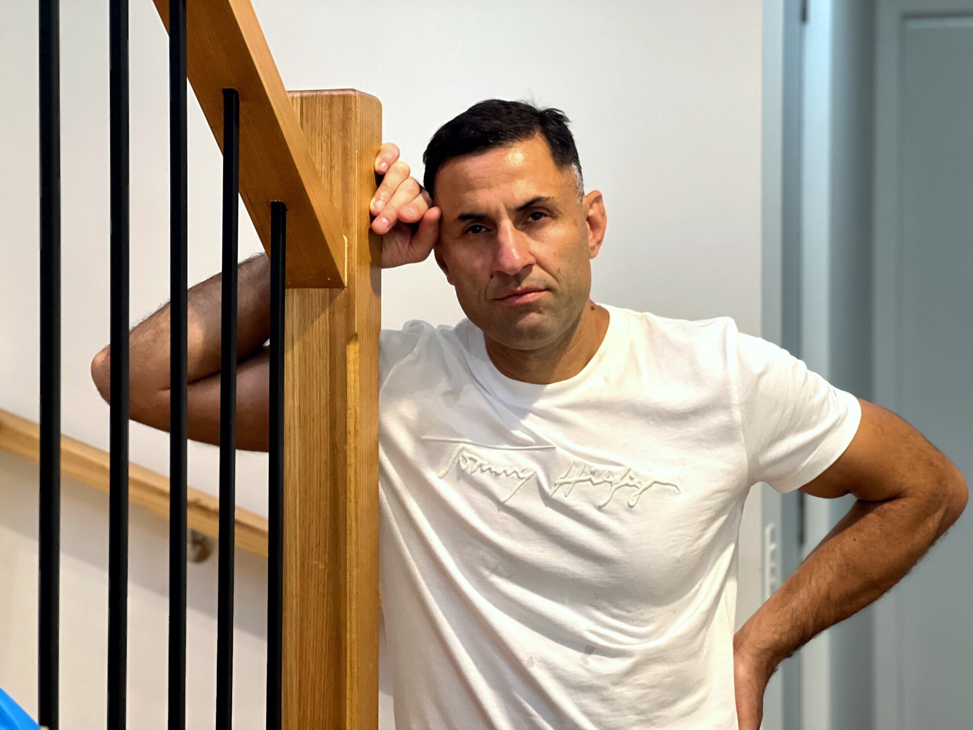 A man looks at the camera resting on the stairs.