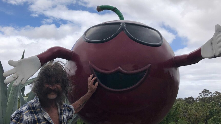 Big Cherry farm owner Joe Campanelli with the 'Big Cherry' statue in Wyuna