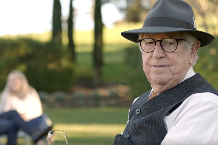 An old man in a hat in a park.