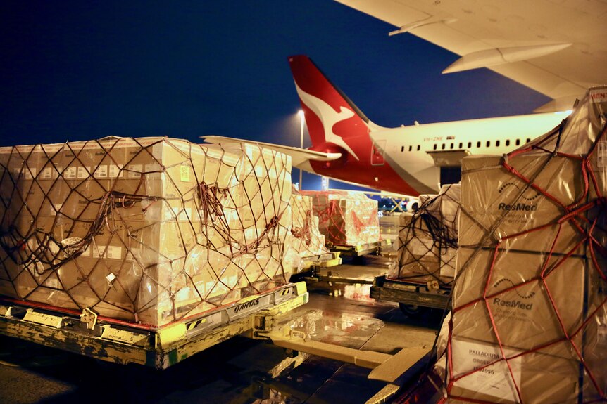 Freight being loaded onto a Qantas plane at night