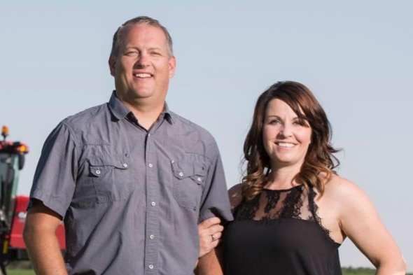 A farming couple from Canada standing on their property