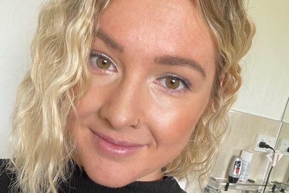 Close up headshot of blond woman looking at camera