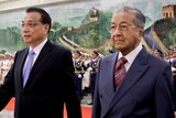 Li Keqiang and Mahathir Mohamad walk together past a guard of honour.