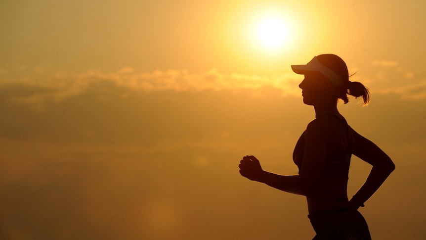 Woman running a marathon at sunset